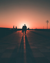 Silhouette di un uomo e una donna abbracciati che camminano in terrazza Mascagni al tramonto