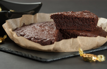 Homebaked Chocolate Brownie In Parchment Paper. Slate Stone.