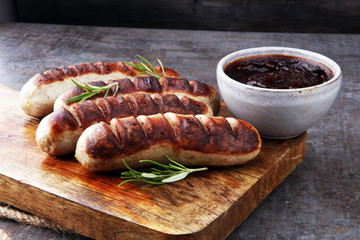 Grilled sausages with sauce ketchup on a wooden table - Home-made Pork Sausages