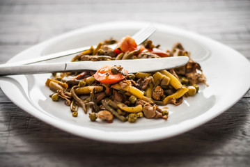 Plate with chicken meat and vegetable on wooden table.