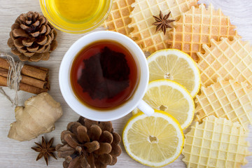 Cup of tea with honey, pinecone, badian, ginger, waffles and cinnamon