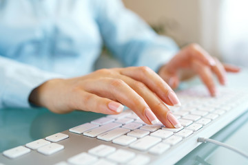 Woman office worker typing on the keyboard