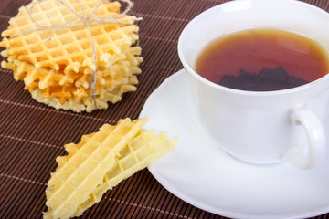 Breakfast with Waffles, Pieces of Waffle and Black Cup of Tea on Wooden Surface