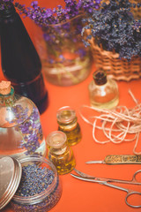 Lavender oil with fresh flowers on orange table