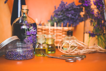 Lavender oil with fresh flowers on orange table