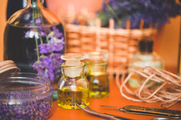 Lavender oil with fresh flowers on orange table