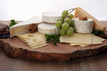 Cheese platter with different cheese on brown wooden plate