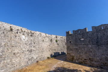 Fototapeta na wymiar Walls of Rhodes old town and inner moat in the Palace of the Grand Master of the Knights of Rhodes (Kastello), a medieval castle in the city of Rhodes, on the island of Rhodes