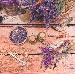 Obraz na płótnie Canvas Lavender oil with fresh flowers on wooden background.