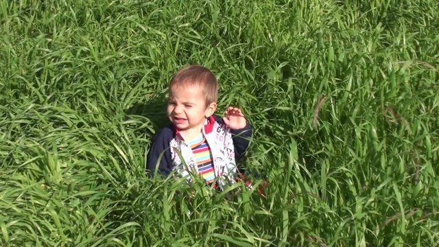 Crying baby in thick grass 