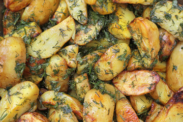 Slices of potatoes appetizing fried and sprinkled with herbs. A simple, beautiful dish prepared without meat is suitable for vegetarians.