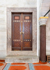 Wooden aged engraved door and marble wall, Suleymaniye Mosque, Istanbul, Turkey