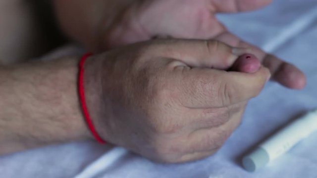 A man piercing his finger and building a blood test