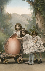 Three little girls with a large Easter egg on a trolley. Date: circa 1910