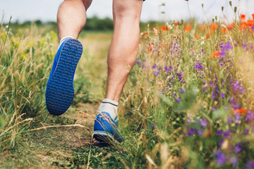 Young man running on poppy field