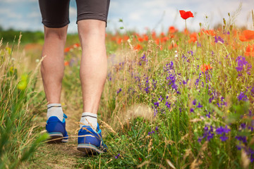Young man running on poppy field