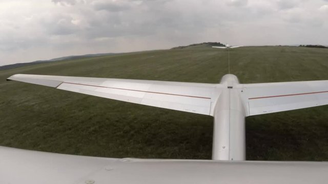 Aerotowing glider start and flight over urban landscape. Footage from action camera placed on aircraft elevator. Soaring under clouds.