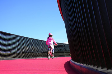 Girl rides bike on pink cycleway in Auckland
