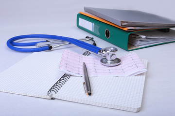 Folder file, stethoscope and RX prescription on the desk. blurred background.