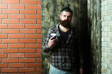 hipster man standing with plastic cup in stylish plaid jacket