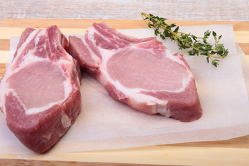Raw pork chops, spices and rosemary on cutting board. Ready for cooking.