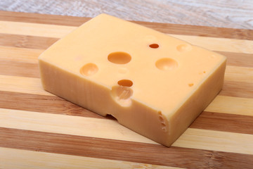 Italian piece of cheese on a wooden cutting board