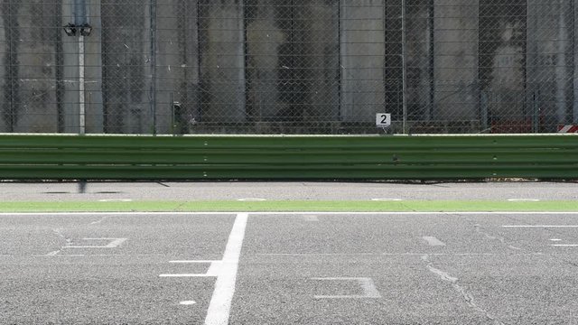 Motorsport racing circuit track straight start finish line and one blurred car crossing frame