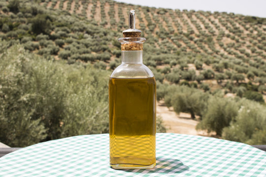 Aceite de oliva virgen extra sobre fondo de olivos