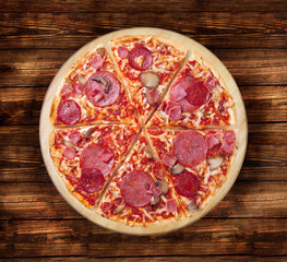 Salami pizza on the  wooden table. This picture is perfect for you to design your restaurant menus. Visit my page. You will be able to find an image for every pizza sold in your cafe or restaurant. 