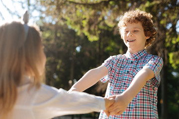 Happy teenager holding hands of his sister