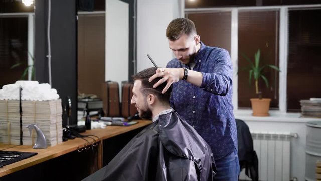 A visitor of a barbershop wants to get a fashionable hairdo in barbershop, an adult man expects the hair line to be trimmed