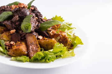 Warm salad with liver and apples on a white background