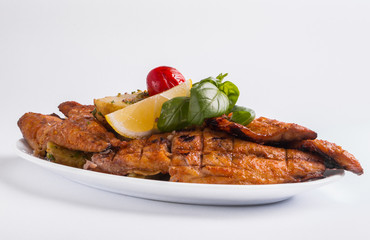 Grilled mackerel with lemon on a white background