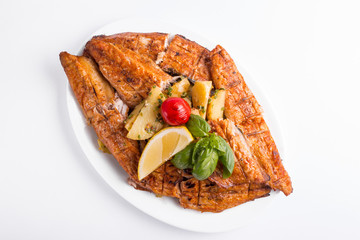 Grilled mackerel with lemon on a white background