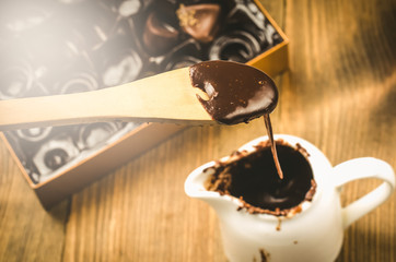 chocolates and liquid chocolate in a cup/liquid chocolate in a cup and candies. Top view