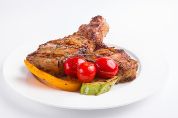 Grilled pork steak and vegetables on a white background