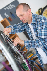 a man repairing bicycle in his workshop