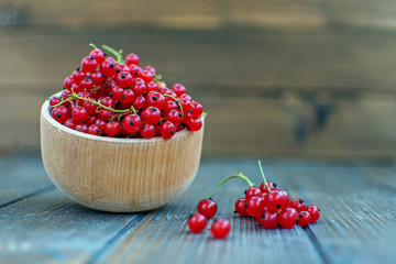Fresh red currants in a wooden bowl. Useful berries and mint. The concept is healthy food, vitamins, diet and vegetarianism.