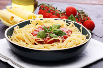 Plate of delicious spaghetti Bolognaise or Bolognese with savory minced beef and tomato sauce garnished with parmesan cheese and basil