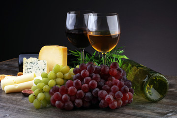 Fototapeta na wymiar Cheese platter with different cheese and grapes and red wine
