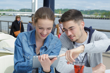 happy couple with tablet pc computer and glasses at terrace