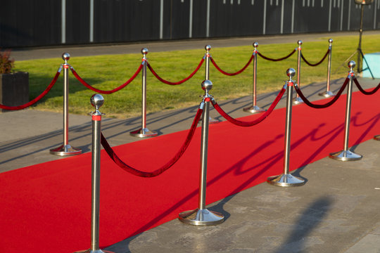 Long red carpet between rope barriers on VIP entrance.