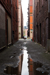 A reflective puddle in a dark alleyway