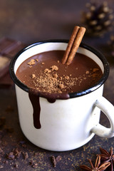 Homemade spicy hot chocolate with cinnamon in enamel mug.