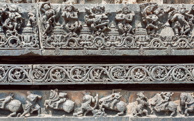 Indian architecture background. Dancing people ruined on traditional style relief, with patterns inside the temple in India.