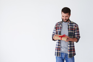 Fototapeta premium Portrait of a smiling casual man looking at gift box