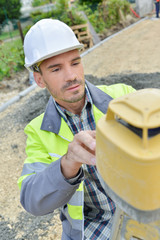 male construction builder taking measurements at construction site