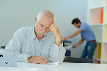 close-up portrait of senior businessman sitting at office