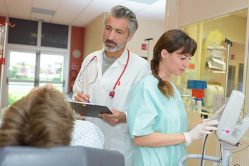 Obraz premium doctor and nurse with tablet pc computer visiting senior patient