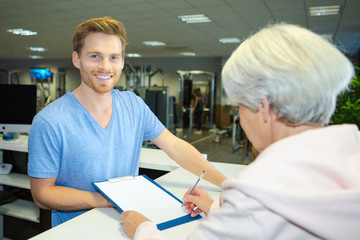 elderly woman registering at fitness center